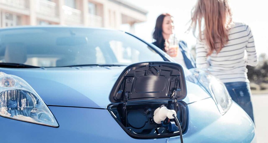 nissan-leaf-charging-with-young-women-standing-near.jpeg